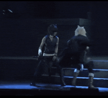 a man in a blue vest is standing on a stage with a sword