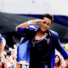 a man wearing a blue shirt and black tank top is smiling