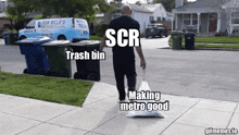 a man is walking down a sidewalk carrying a bag that says scr and trash bin