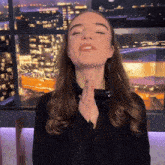 a woman is praying with her eyes closed and her hands folded