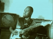 a man is playing a guitar in front of a speaker that says ' amplifier ' on it