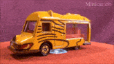 a yellow toy bus with a zebra print on the side of it