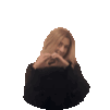 a woman in a black sweater is making a heart with her hands .