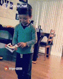 a boy in a green shirt is standing in a living room with a sharechat icon on the bottom right
