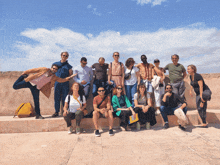 a group of people are posing for a picture with a blue sky in the background
