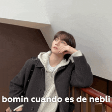 a man leaning on a railing with the words bomin cuando es de nebli written below him