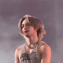 a man wearing a tank top that says just fine is standing on a stage