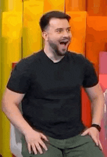 a man with a beard is sitting in a chair with his mouth open and making a funny face .