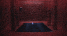 a dark room with a blue light coming out of the corner of the room .
