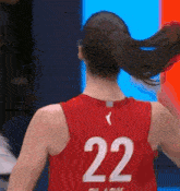 the back of a female basketball player wearing a red jersey with the number 22 on it is shown .