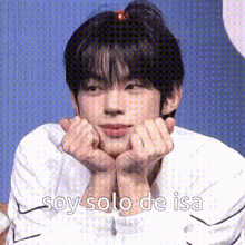 a young man is making a heart shape with his hands on his face and says `` soy solo de isa '' .