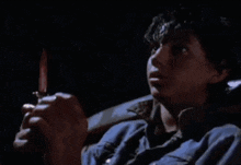 a man in a blue shirt is holding a knife