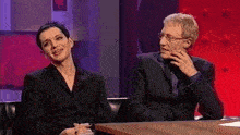 a man and a woman are sitting at a table and smiling