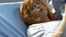 a woman with red hair is laying in a hospital bed with netflix written on the bottom