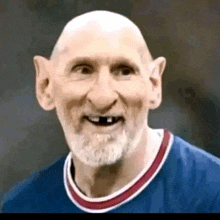 a bald man with a beard and missing teeth is wearing a blue jersey