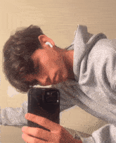 a young man takes a selfie with his phone