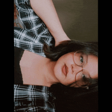 a girl wearing glasses and a plaid shirt