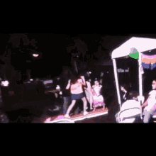 a group of people are dancing in a dark room