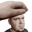 a hand is holding a man 's head in a pixel art .