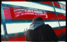 a man in a hoodie looks at a sign that says ' xm9 ' on it
