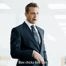 a man in a suit and tie is saying " bow chicka bow bow "