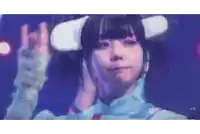a girl wearing a virtual reality headset is making a peace sign with her hands .