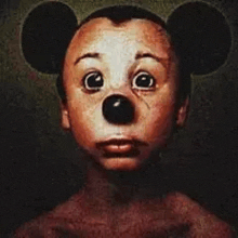 a close up of a mickey mouse doll with a big nose and ears .