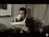 a man drinking a cup of coffee while reading a newspaper called about time