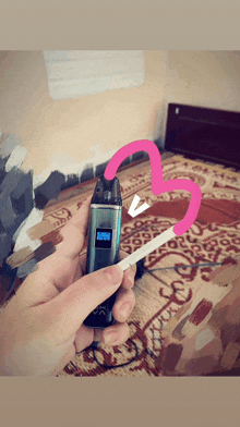 a person holding a device with a heart drawn on it and a cigarette in their hand