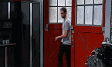 a man is walking into a garage with a red door and a license plate that says hlt 242
