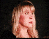 a close up of a woman 's face with blonde hair making a surprised face .