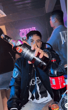 a man is holding a bottle of bacardi and a bottle of coca cola