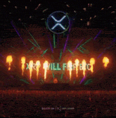 a crowd of people watching a stage with a large x on it that says xrp will fire