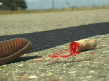 a person 's foot is standing next to a bloody object