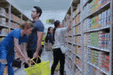 a group of people are shopping in a grocery store and one woman is holding a yellow basket
