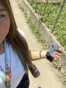 a woman wearing a northeastern t-shirt is holding a camera strap