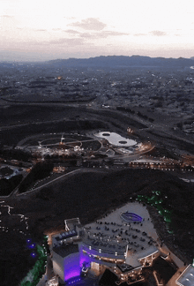 an aerial view of a city with a purple building in the middle