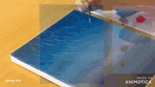 a person is painting on a piece of paper that says made in animonica