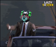 a man in a suit and tie is driving a car with lazy soccer written on the bottom of the screen