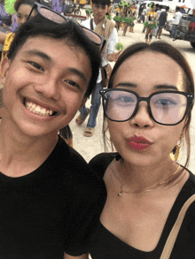 a man and a woman are posing for a picture and the woman has red lipstick on her lips