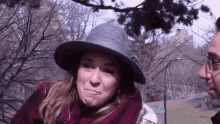a woman wearing a hat and scarf is talking to a man .