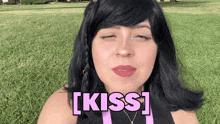 a woman blowing a kiss with the word kiss in pink