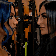 two women are looking at each other and one of them is wearing a necklace that says ' the next thing ' on it