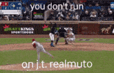 a baseball game is being played with the words " you do n't run on j.t. realmuto " on the bottom
