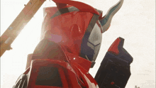 a red and black robot is standing in front of a white background