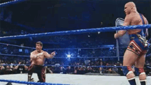 two wrestlers are fighting in a wrestling ring with a referee in the background