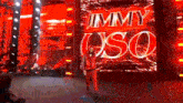 a wrestler is walking on a stage with a large screen behind him that says jimmy uso