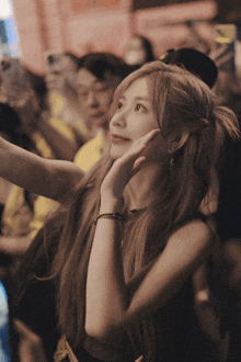 a woman taking a picture of herself in a crowd of people