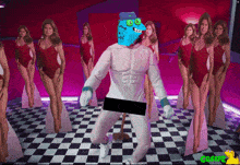 a group of women in red swimsuits are standing behind a man in a white costume