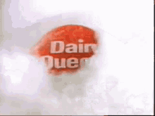 a close up of a dairy queen logo on a white background with smoke coming out of it .